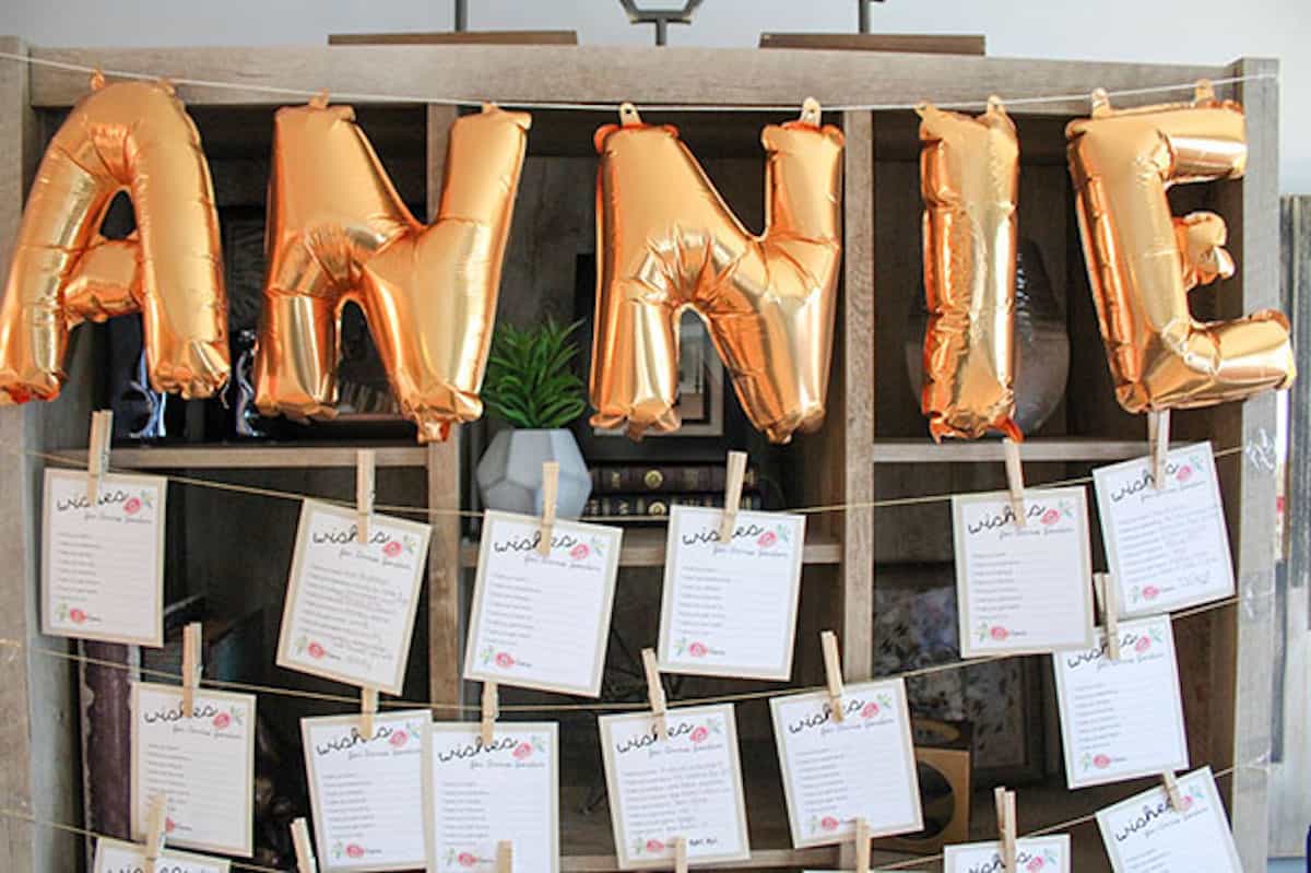 Wish cards hanging on display with balloons spelling out baby's name