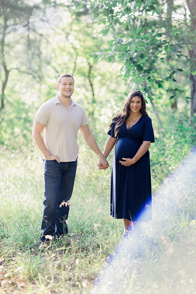 husband and wife posing for maternity photos before baby's arrival