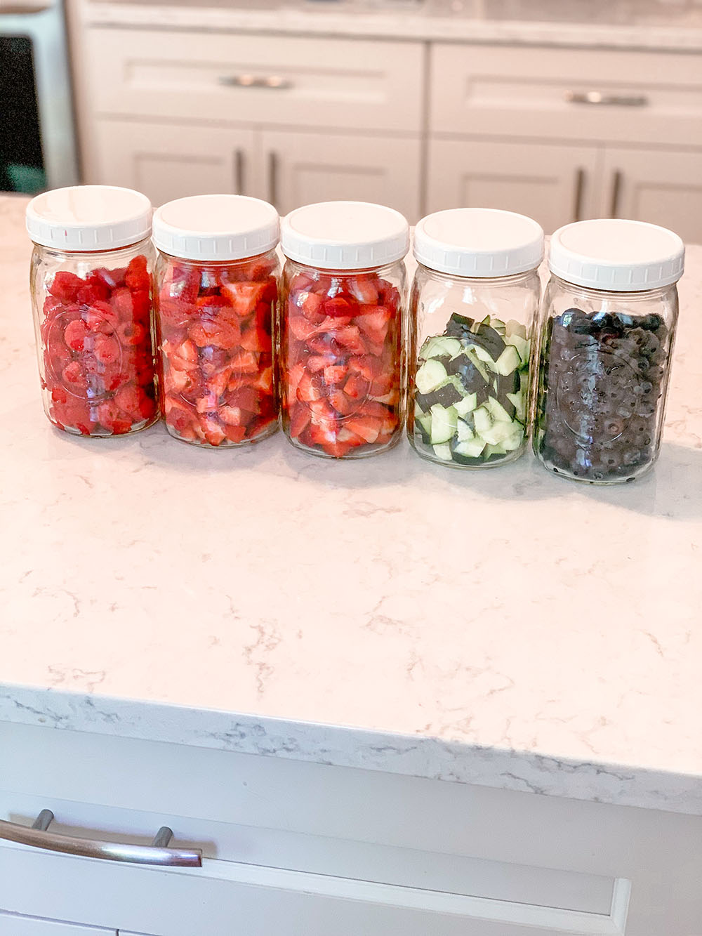 Glass mason jars full of cut up fruit and veggies for food prep