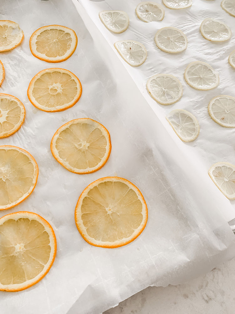 Oranges and lemons sliced thinly and placed on baking sheets to dry them out in the oven