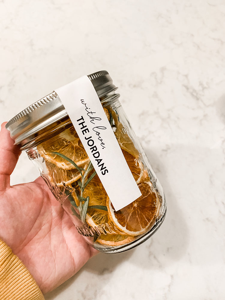 Jar full of stovetop potpourri with dried citrus, spices, rosemary, and more