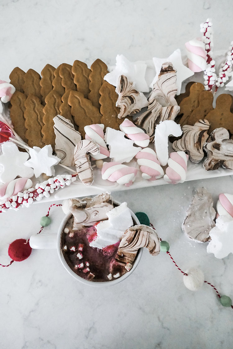 Homemade marshmallows in shapes of trees, stars, candy canes with tray of hot cocoa bar ingredients