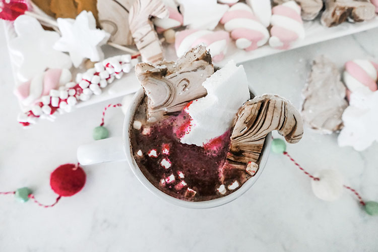 Homemade marshmallows in shapes of trees, stars, candy canes with tray of hot cocoa bar ingredients