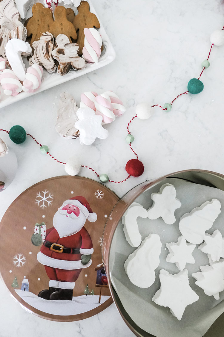 Homemade marshmallows in shapes of trees, stars, candy canes with tray of hot cocoa bar ingredients