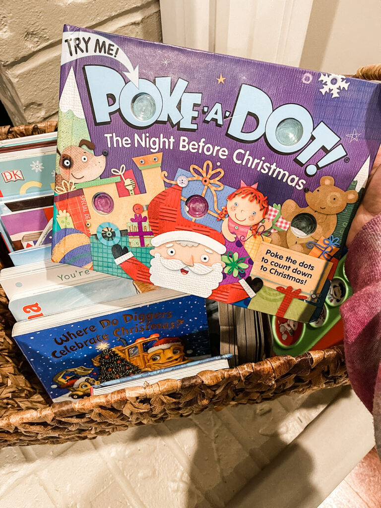 Family holiday book basket on the ledge of fireplace with holiday books inside showing "Poke-a-Dot The Night Before Christmas".