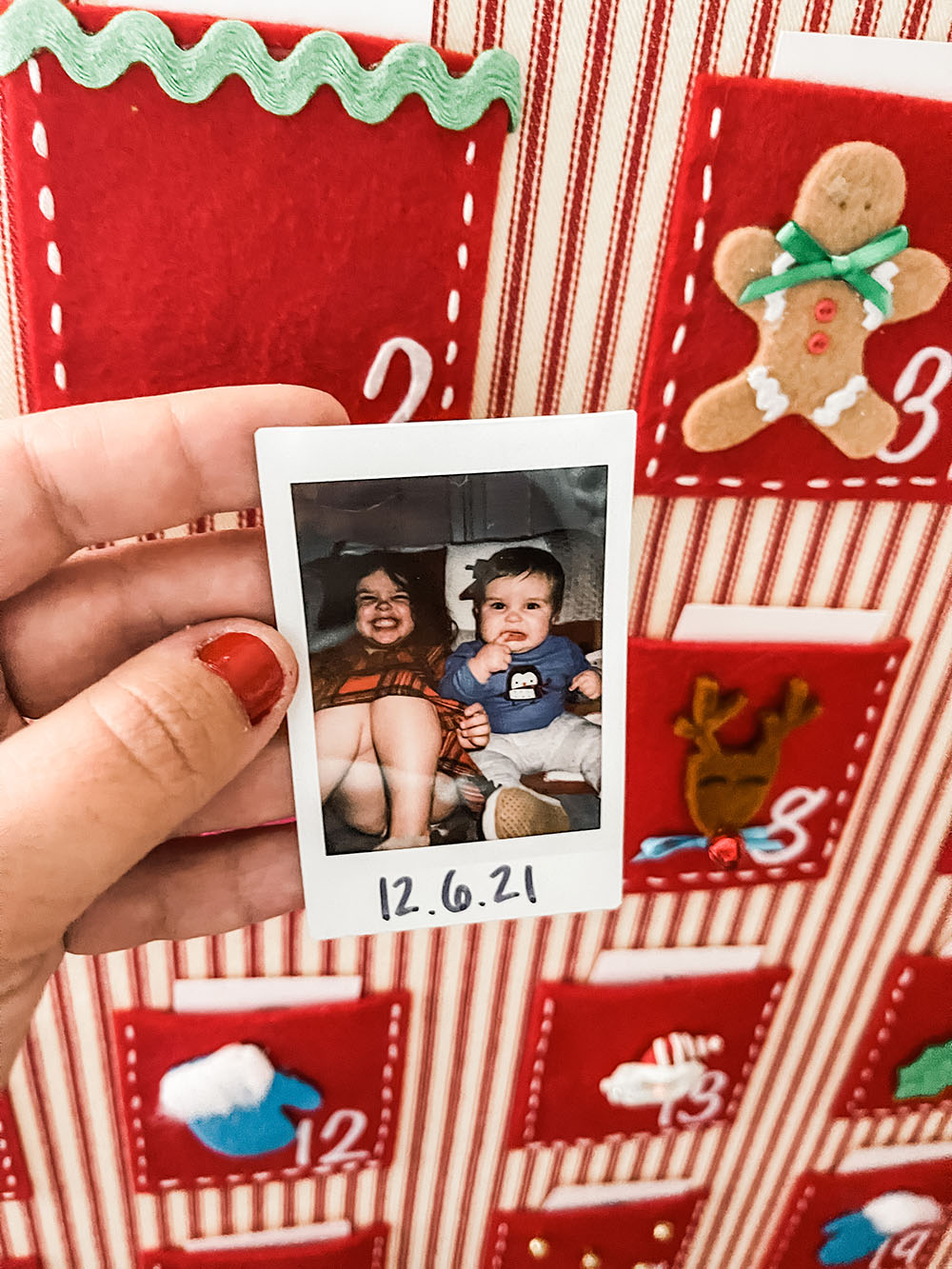 Advent calendar in background with mini polaroid of brother and sister from that day's advent activity. 