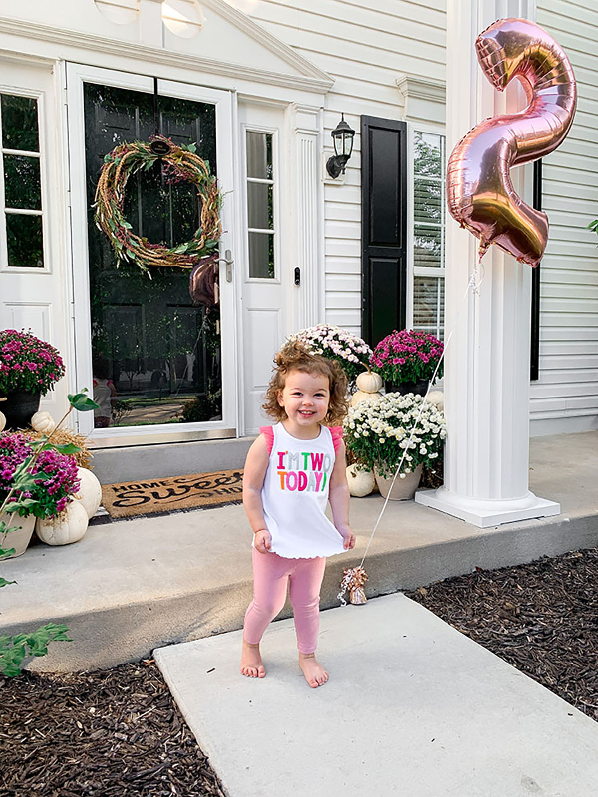 Oh Twodles Birthday toddler girl outside holding rose gold #2 balloon