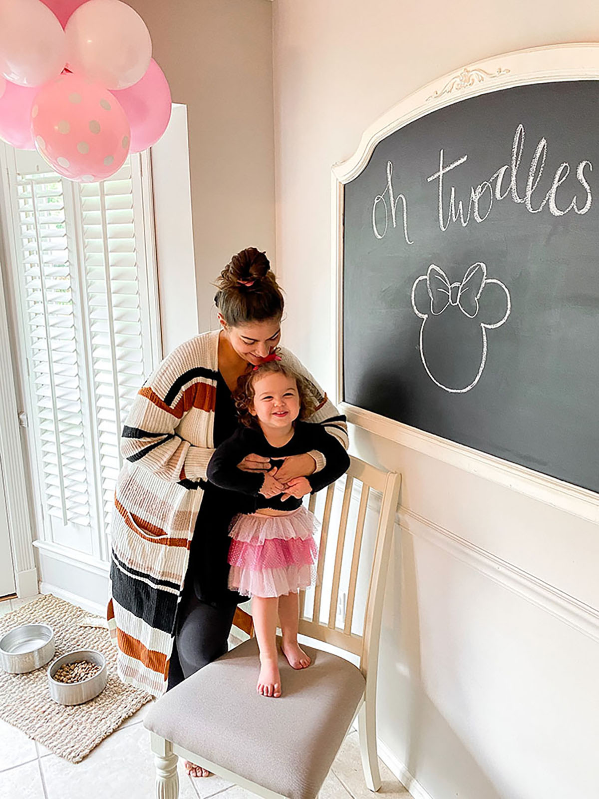 Oh Twodles Birthday drawing on chalkboard with little girl in pink polka dot tutu smiling with mom