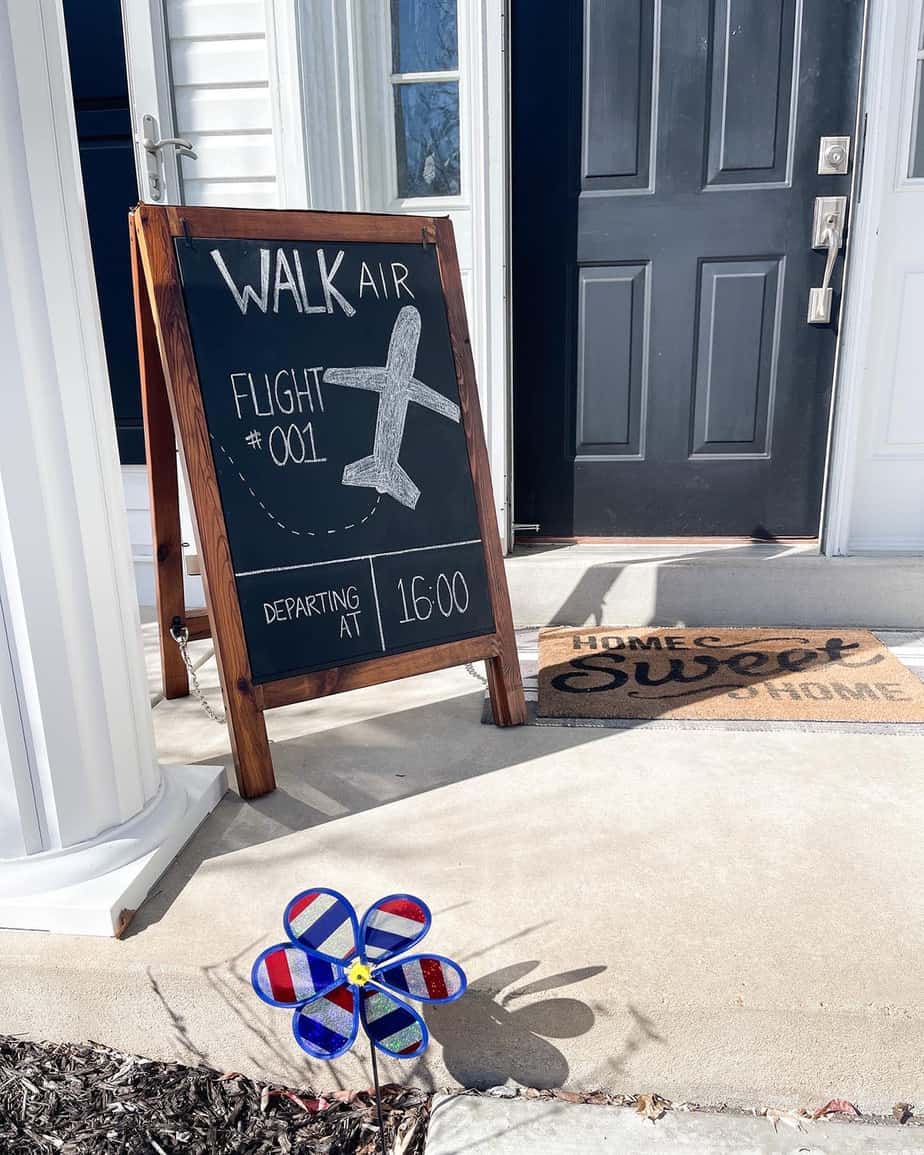 Chalkboard reading "Walk Air Flight #001" on front porch