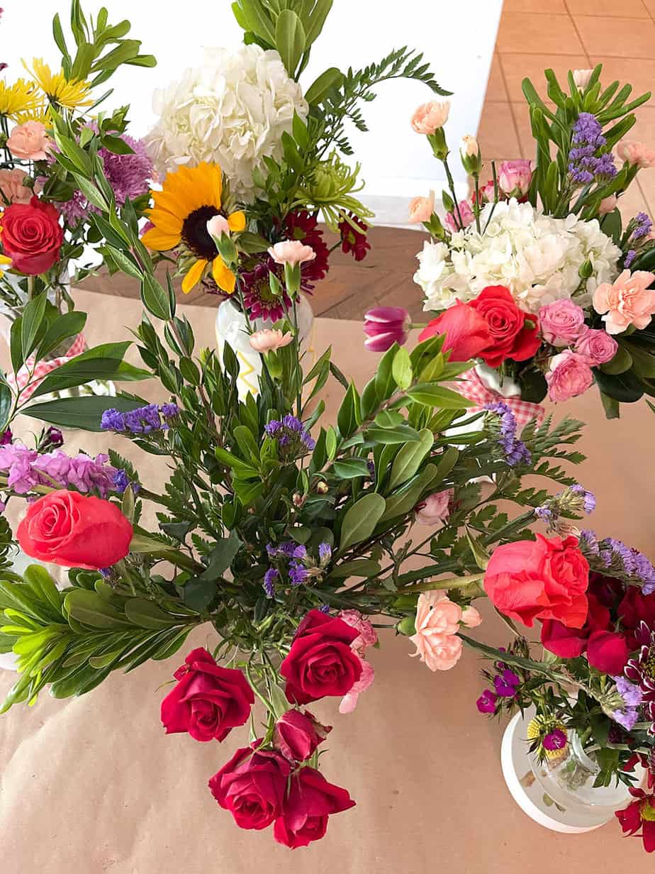 flower arranging party with a variety of fresh flower bouquets arranged on brown kraft paper