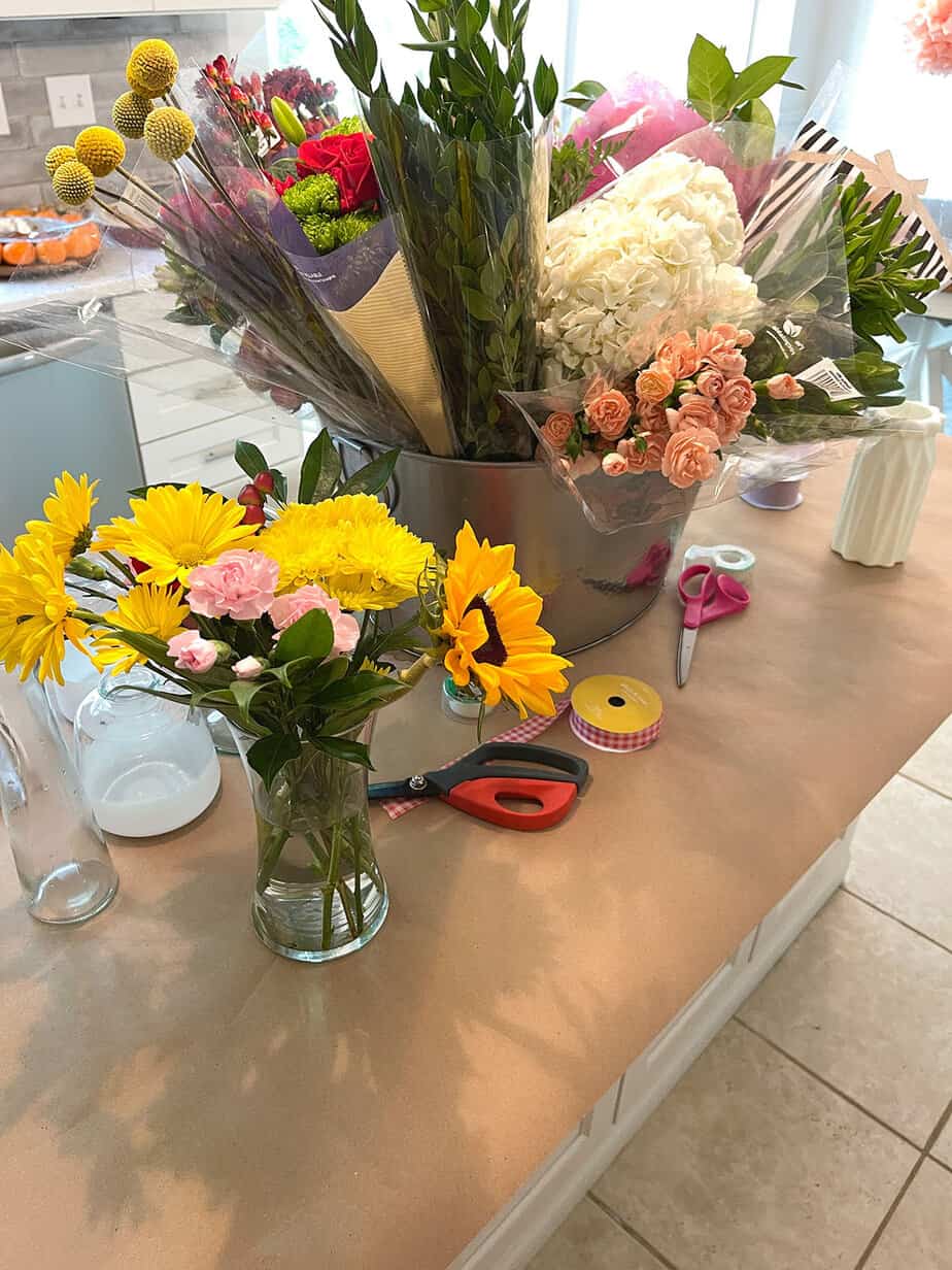 flower arranging party with a variety of fresh flower bouquets arranged on brown kraft paper