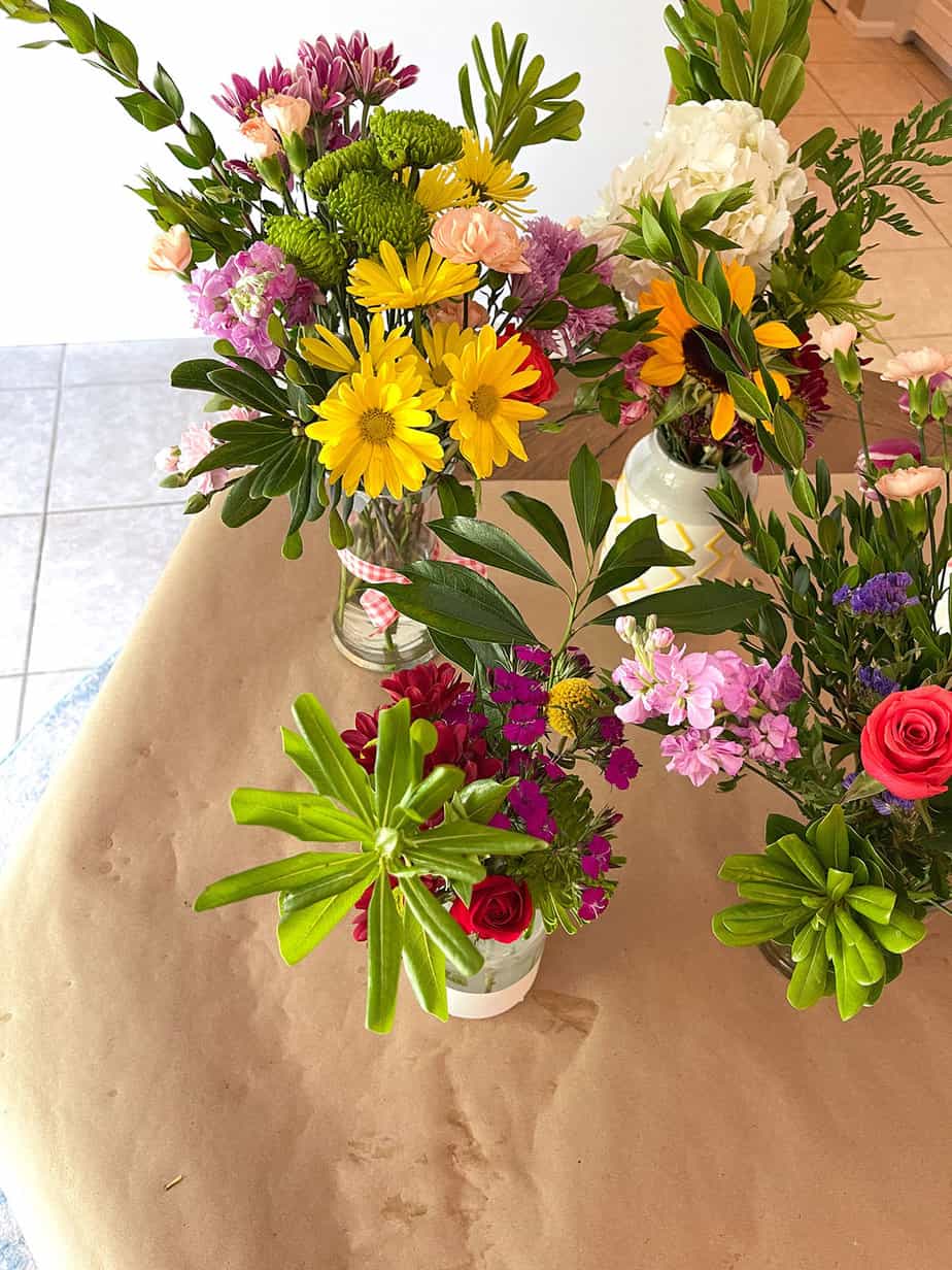 flower arranging party with a variety of fresh flower bouquets arranged on brown kraft paper