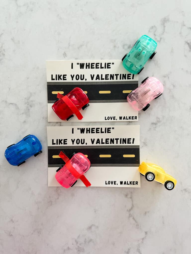 Car themed valentines with a little track printed on paper and mini toy car taped onto the card with colorful washi tape.