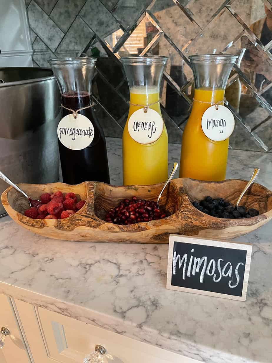 Mimosa station set up with fresh juice and fruits for a baby shower.