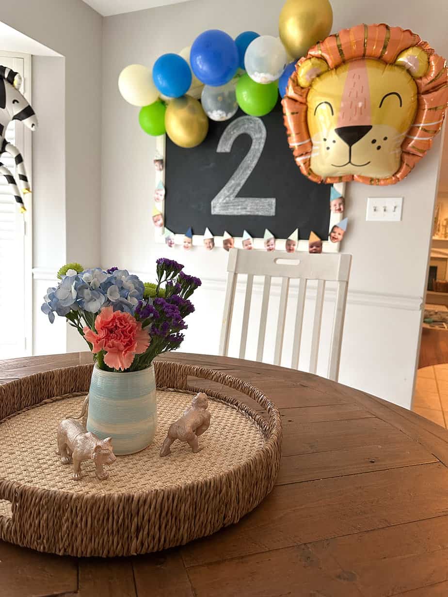 two wild animal party with blue, green and gold balloon garland, large lion and zebra balloons, and a chalkboard that says "2" 