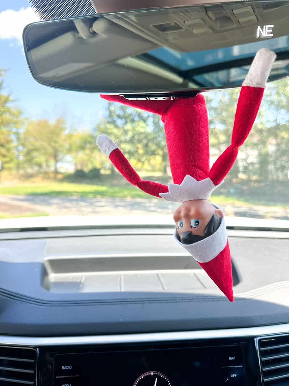 elf on the shelf hanging from the rear view mirror to surprise kids on the way to school