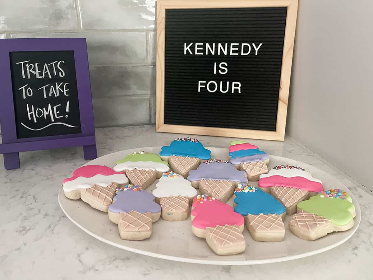 ice cream party favors of brightly colored sugar cookies in the shape of ice cream cones and ice cream cone shaped bubble containers