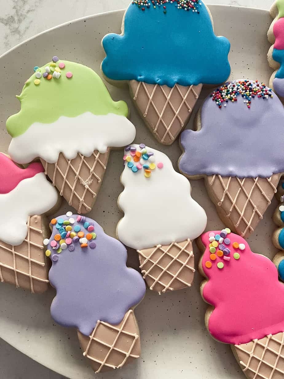 ice cream shaped cookies in lime green, blue, hot pink, and purple colors with sprinkles on them