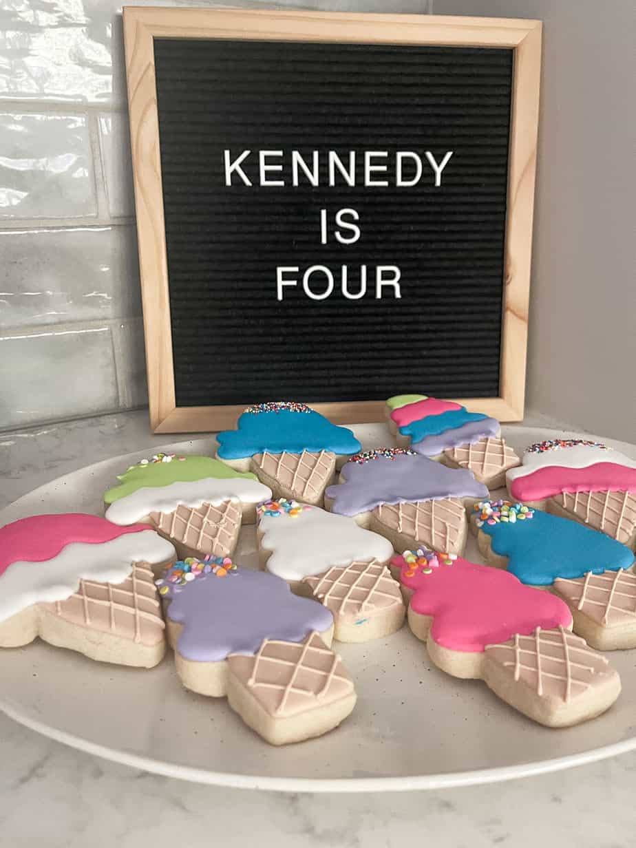 ice cream party favors of brightly colored sugar cookies in the shape of ice cream cones and ice cream cone shaped bubble containers