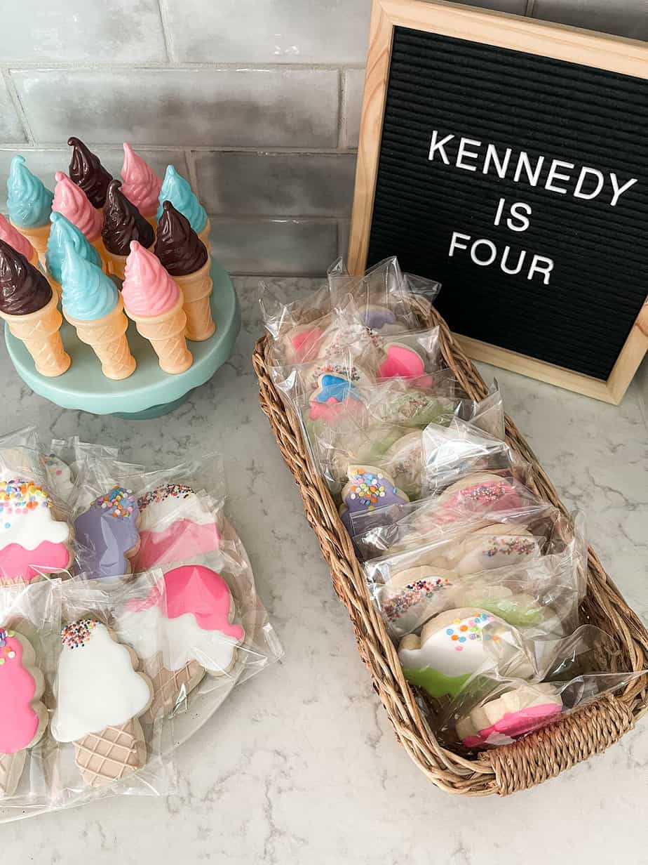 ice cream party favors of brightly colored sugar cookies in the shape of ice cream cones and ice cream cone shaped bubble containers