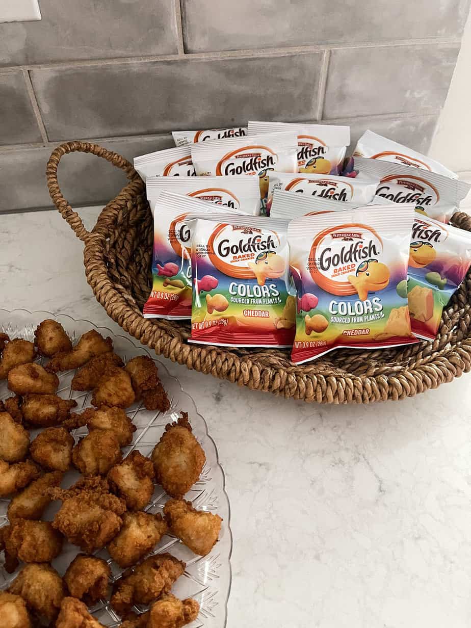 colorful goldfish crackers and chicken nuggets on clear tray sitting on counter for a kids birthday party
